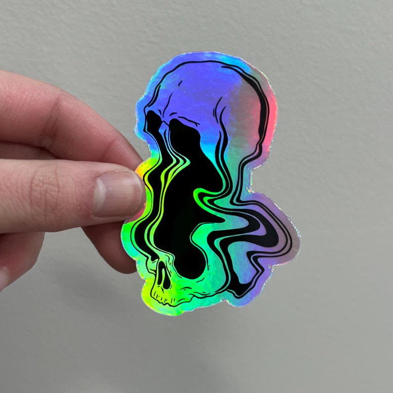 May include: A holographic sticker of a skull with a black and green liquid dripping from it.
