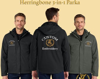 Può includere: Tre parka 3 in 1 personalizzati con ricamo a spina di pesce in nero e verde oliva. Ogni giacca presenta un cappuccio e un logo personalizzato. Il testo "Custom Embroidered Herringbone 3-in-1 Parka" è visualizzato nella parte superiore dell'immagine.