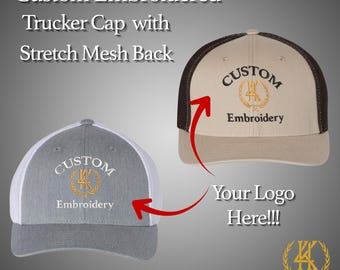 May include: Two custom embroidered trucker caps. One is gray with a white mesh back, the other is tan with a brown mesh back. Both caps have the word "CUSTOM" embroidered above "Embroidery". The text "Your Logo Here!!!" is also visible.