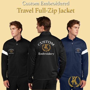 Puede incluir: Tres chaquetas de viaje con cremallera completa en negro y azul marino. La chaqueta negra tiene una franja blanca en la manga y el texto "Custom Embroidery". La chaqueta azul marino tiene una franja blanca en la manga y el texto "Custom Embroidery". La parte trasera de la chaqueta negra tiene el texto "Custom Embroidery".