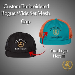 May include: Two custom embroidered Rogue Wide Set Mesh Caps are displayed. One is black with a black mesh back, and the other is teal with an orange mesh back. Both caps feature the text "CUSTOM Embroidery" and a logo.
