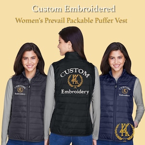 Könnte beinhalten: Individuell bestickte, verpackbare Pufferwesten in Schwarz und Marineblau. Die Westen haben ein individuelles Logo und die Worte "Custom Embroidery" auf der Vorder- und Rückseite gestickt. Die Westen werden an einem Model gezeigt.