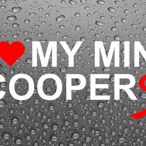 May include: A white decal with red heart and the text "I love my mini cooper s". The decal is on a grey background with water droplets.