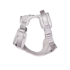 May include: A light gray dog harness with adjustable straps and a secure buckle closure. The harness features reflective white trim for enhanced visibility. The design includes a padded chest and back area for comfort and a zipper closure.