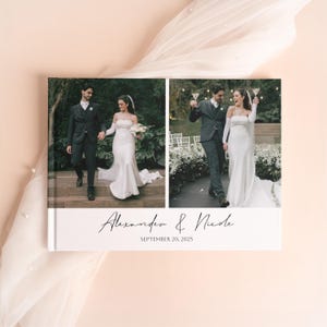 Pode incluir: Um &aacute;lbum de fotos de casamento com duas imagens de um casal. O &aacute;lbum tem uma capa branca com os nomes "Alexander & Nicole" e a data "SEPTEMBER 20, 2025" em escrita elegante. O fundo &eacute; de uma cor suave e neutra.