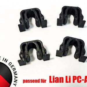 Könnte beinhalten: Vier schwarze Kunststoffclips für ein Computergehäuse auf weißem Hintergrund. Der Text "4x" befindet sich oben links. Der Text "Made in Germany" ist sichtbar, zusammen mit "passend für Lian Li PC-A77".
