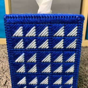 May include: Blue and white tissue box cover with a geometric pattern of white triangles on a blue background.