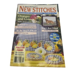 May include: A magazine cover titled "New Stitches" with the text "Oranges and Lemons" and "Man's Best Friend." The cover features images of cross-stitch projects, including citrus fruits and a Golden Retriever.