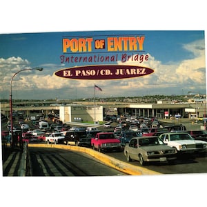 Könnte beinhalten: Eine Vintage-Postkarte mit der "Port of Entry International Bridge" zwischen El Paso und Cd. Juarez. Das Bild zeigt einen geschäftigen Grenzübergang mit zahlreichen Fahrzeugen, einer wehenden amerikanischen Flagge und einem bewölkten Himmel.