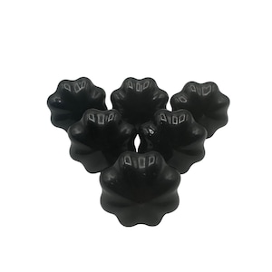 May include: Six black, star-shaped knobs arranged in a triangular pattern. Each knob has a glossy finish and a central, recessed area. The knobs are likely for furniture or decorative purposes.