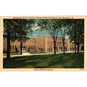 Peut inclure: Carte postale ancienne représentant le stade Illinois Memorial à Mooseheart, Illinois. L'image montre un grand bâtiment beige avec de nombreuses fenêtres et portes, encadré par de grands arbres et une pelouse verte. Le texte comprend "Mooseheart" et "Illinois Memorial Stadium."