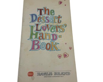 Może przedstawiać: Książka kucharska w stylu vintage zatytułowana "The Dessert Lovers' Hand-Book" z kolorowym tekstem i ilustracjami serc. Okładka zawiera również logo Borden i "Eagle Brand Sweetened Condensed Milk".