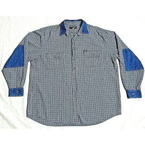 May include: A long-sleeved plaid shirt with blue denim patches on the elbows. The shirt has a button-down collar and a checkered pattern in black and white.