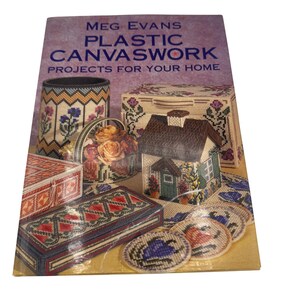 May include: A book titled "Meg Evans Plastic Canvaswork Projects for Your Home" with a colorful image of various plastic canvas projects, including a house, a basket, a box, and coasters.