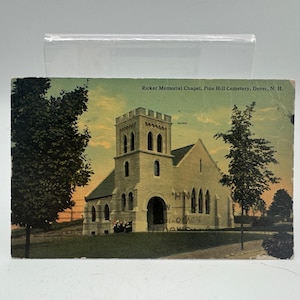 May include: A vintage postcard showing the Ricker Memorial Chapel at Pine Hill Cemetery, Dover, N.H. The chapel is a light-coloured stone building with a tall, square bell tower and arched windows. The text "Ricker Memorial Chapel, Pine Hill Cemetery, Dover, N. H." is visible.
