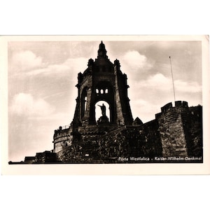Op de afbeelding: Vintage zwart-wit ansichtkaart met het Kaiser Wilhelm Monument in Porta Westfalica, Duitsland. Het monument is een grote, sierlijke structuur met een standbeeld van keizer Wilhelm I. De lucht is bewolkt.