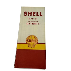 May include: A vintage Shell Map of Metropolitan Detroit. The map features the Shell logo, a yellow and red colour scheme, and the text "Shell Map of Metropolitan Detroit."