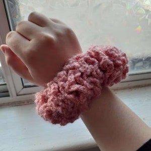 May include: A pink crocheted hair scrunchie.