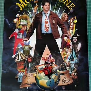 May include: A movie poster for Monkeybone featuring Brendan Fraser in a brown jacket and white shirt with a red patterned tie. The poster includes various characters, a globe, and text including the title Monkeybone and the phrase Bone 2 B Bad.