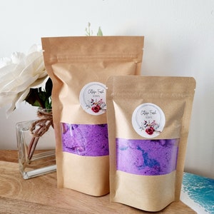 May include: Two brown paper bags containing purple bath salts. The bags feature a white label with the text "Cottage Fresh Scents" and a watercolour floral design.