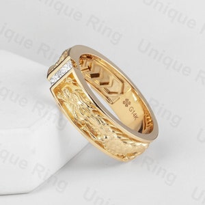 May include: A gold band ring with a textured design and a row of small diamonds. The ring is marked with "G14K" on the inside.