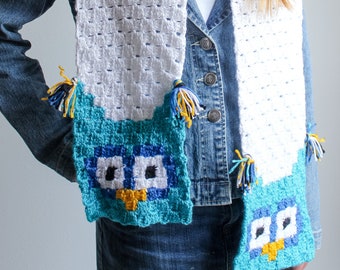 May include: White crochet scarf with blue and yellow owl designs. The scarf has tassels on the ends.