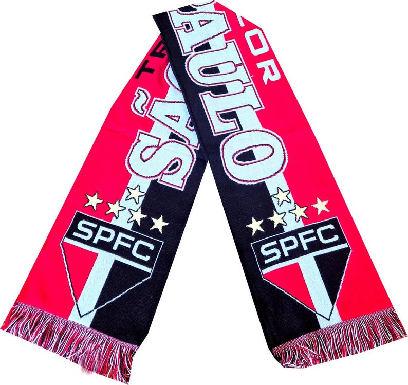 Pu&ograve; includere: Una sciarpa lavorata a maglia rossa, nera e bianca con la scritta "SAO PAULO" e "SPFC" in evidenza. La sciarpa presenta un bordo con frange e dettagli a stella, che mostrano i colori e il marchio della squadra.