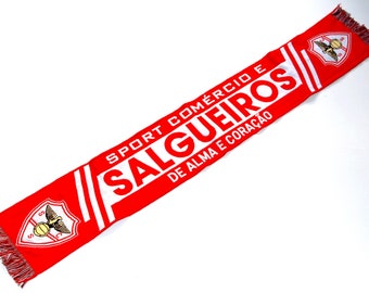 May include: Red and white soccer scarf with the text "Sport Comercio Salgueiros De Alma e Coração" and a white and gold emblem of a bird with a soccer ball.