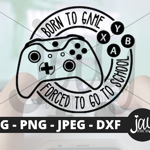May include: Black and white graphic design of a video game controller with the text "Born to Game Forced to Go to School" in a circle around it. The controller has buttons labeled "A", "B", "X", and "Y".