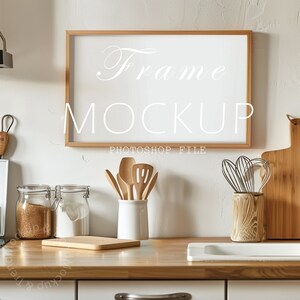 May include: A kitchen scene featuring a wooden frame mockup with the word "Frame" and "Mockup" in white script. Kitchen utensils, including wooden spoons, a whisk, and cutting boards, are arranged on a wooden countertop. Jars of ingredients are also visible.