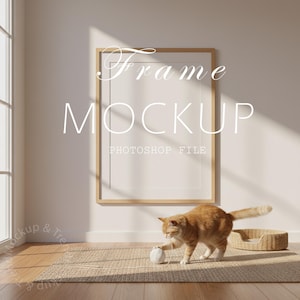 May include: A vertical frame mockup with the text "Frame Mockup Photoshop File" in a bright room. An orange tabby cat plays with a ball of yarn on a woven rug near the frame. A cat bed is in the background.