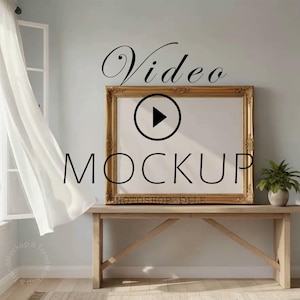 Puede incluir: Maqueta de vídeo con marco dorado adornado. La palabra «Video» está arriba y «MOCKUP» debajo de un botón de reproducción. El marco está sobre una mesa de madera clara con una pequeña planta en maceta. Una cortina blanca transparente ondea.