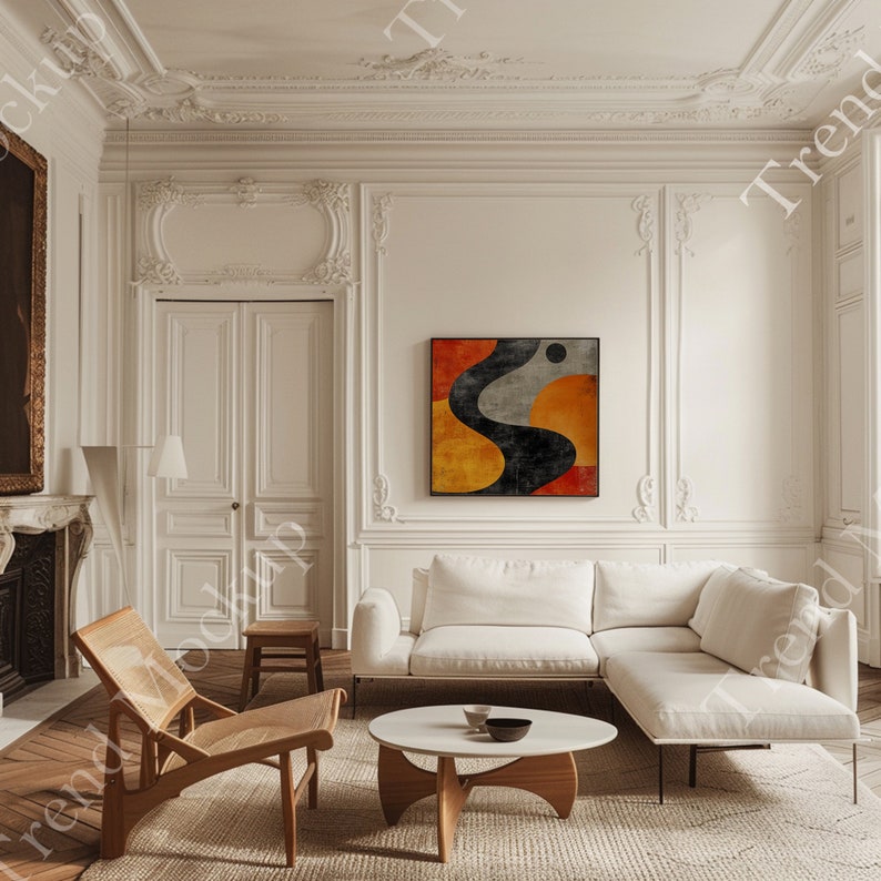 May include: A stylish living room featuring a white corner sofa, a round coffee table, and a wooden chair. An abstract artwork with black, orange, and grey forms adorns the wall. The room has detailed white moulding and a neutral rug.