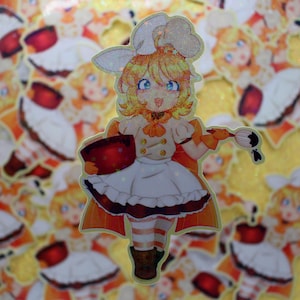 May include: A glittery sticker of a cartoon chef with blonde hair, blue eyes, and a white chef's hat. The chef is holding a red bowl and a paintbrush with black paint. The chef wears a white apron and a cape with orange and brown accents.
