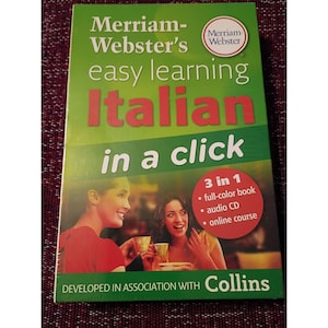 Könnte beinhalten: Ein grünes Buch mit dem Titel "Merriam-Webster's easy learning Italian in a click". Das Cover zeigt zwei Frauen und listet "3 in 1" Funktionen auf: Vollfarb-Buch, Audio-CD und Online-Kurs.