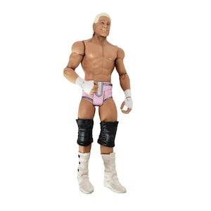 May include: Action figure of a muscular man with blonde hair, wearing pink and white trunks, black knee pads, and white boots. The figure has white wristbands and is posed standing upright.