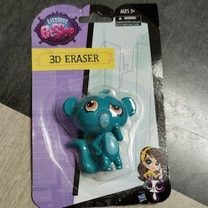 May include: A blue 3D eraser shaped like a monkey from the Littlest Pet Shop toy line. The eraser is packaged on a card with the Littlest Pet Shop logo and the words "3D Eraser".