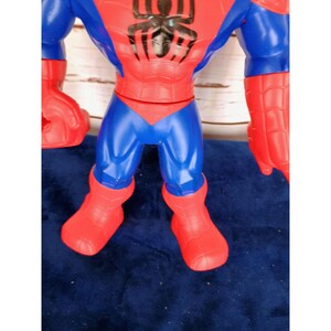 Puede incluir: Una figura de acci&oacute;n de pl&aacute;stico roja y azul de Spiderman. La figura tiene un logotipo de ara&ntilde;a negro en el pecho y botas rojas y azules.