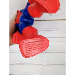 Puede incluir: Figura de acci&oacute;n de pl&aacute;stico rojo y azul de Spider-Man. La figura est&aacute; de pie sobre sus pies con los brazos levantados. La figura tiene un aviso de derechos de autor en la parte inferior de sus pies que dice: TM & &copy; 2018 Marvel & Subs &copy; 2018 Hasbro. Pastuchet, RI 02881 USA All Rights Reserved. Made in China C-023E #E4147 #E4842