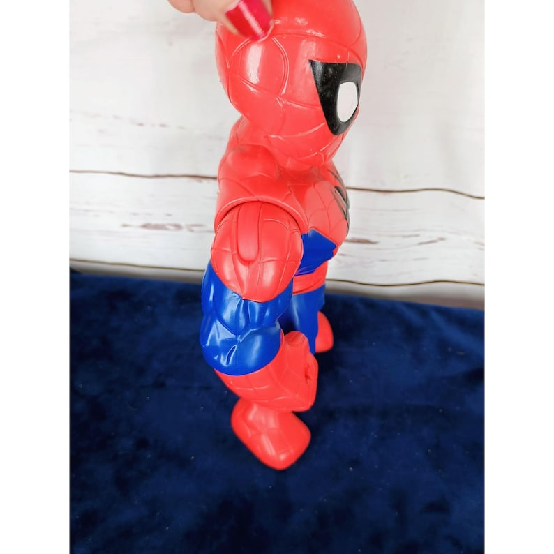 Puede incluir: Una figura de acci&oacute;n de pl&aacute;stico roja y azul de Spiderman. La figura tiene un dise&ntilde;o detallado con un patr&oacute;n de telara&ntilde;a en el traje.