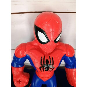 Puede incluir: Figura de acci&oacute;n de pl&aacute;stico roja y azul de Spiderman con un logotipo de ara&ntilde;a negro en el pecho. La figura tiene una cara detallada con ojos blancos y una m&aacute;scara negra.