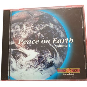 May include: A CD case with the words "Peace on Earth Volume 1" in white over an image of Earth. The Winn-Dixie logo is at the bottom. The case is in a clear plastic sleeve.