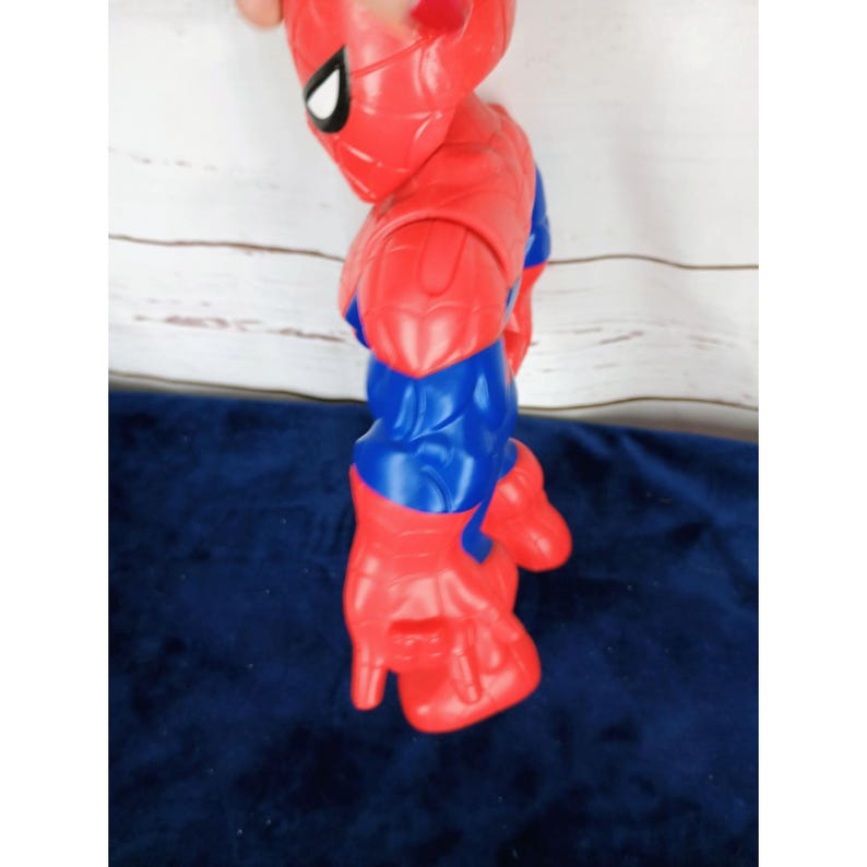 Puede incluir: Una figura de acci&oacute;n de pl&aacute;stico roja y azul de Spiderman con un dise&ntilde;o de telara&ntilde;a. La figura est&aacute; en posici&oacute;n con los brazos levantados y los pu&ntilde;os cerrados.