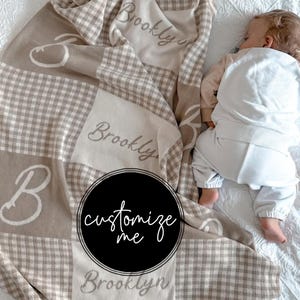 May include: A beige and white checkered baby blanket with the name "Brooklyn" embroidered on it. The blanket has a large "B" initial and the words "customize me" in a black circle.
