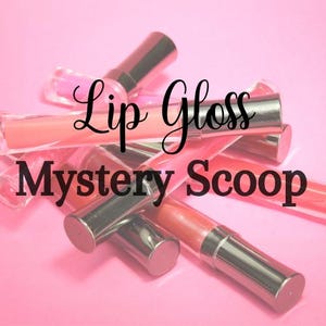 Peut inclure: Plusieurs tubes de gloss à lèvres avec des bouchons argentés et diverses teintes de rose et de pêche. Le texte "Lip Gloss Mystery Scoop" est écrit en script noir sur les gloss, sur fond rose.