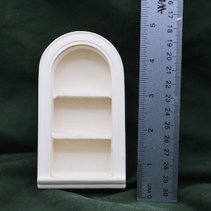 May include: White painted wooden arched shelf unit with three shelves. The shelf unit is 6 inches tall.