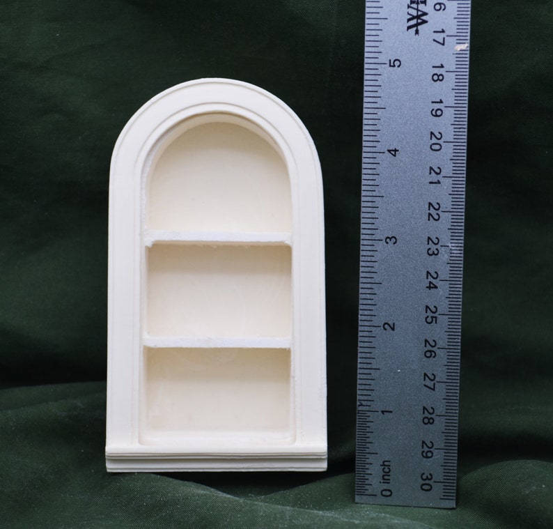 May include: White painted wooden arched shelf unit with three shelves. The shelf unit is 6 inches tall.