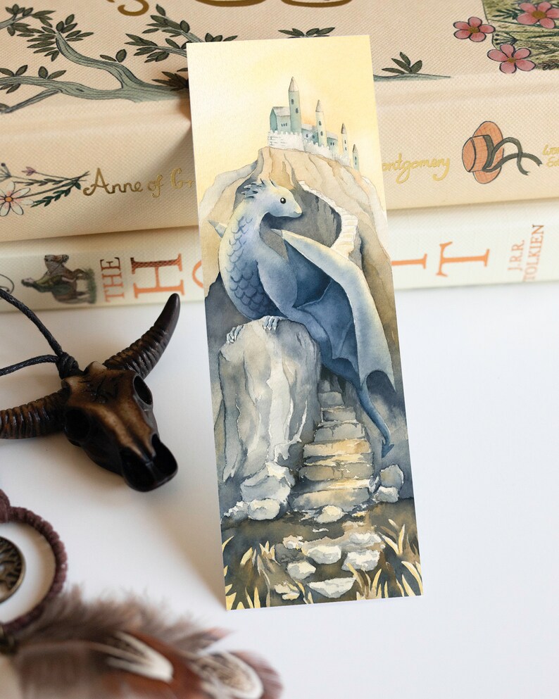 K&ouml;nnte beinhalten: Ein Aquarellbild eines blauen Drachen, der auf einem Felsen sitzt, mit einer Steintreppe, die zu einem Schloss in der Ferne f&uuml;hrt. Der Drache hat Fl&uuml;gel und einen langen Schwanz. Der Hintergrund ist hellgelb.