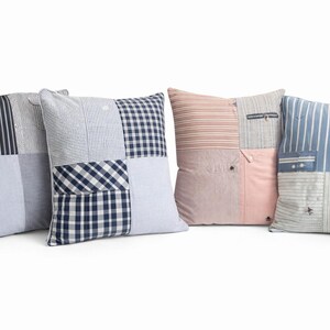 May include: Four square cushions with patchwork designs. The cushions feature various fabrics, including stripes, checks, and solid colours in shades of blue, pink, and white. Some cushions have pockets.