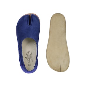 May include: Blue split-toe ballet flats with a matching sole and a separate beige insole. The flats have a soft, suede-like texture. The label reads "Antap, Handmade in Gaziantep Turkey".